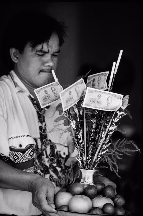 Người đàn ông bưng mâm đồ lễ trong một ngôi chùa, 1997. Ảnh: Philip Jones Griffiths / Magnum Photos.