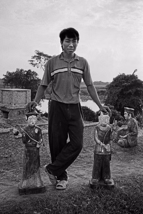 Người thanh niên bên những bức tượng thờ, 1998. Ảnh: Philip Jones Griffiths / Magnum Photos.