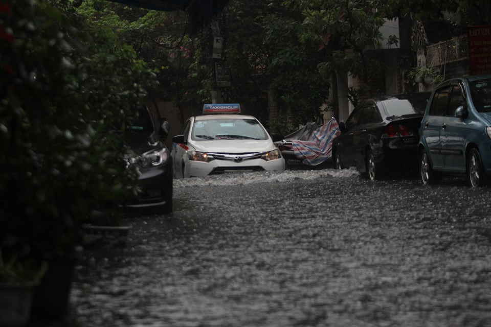 Trên phố Đặng Văn Ngữ, mực nước ngập có chỗ đến nửa bánh xe ô tô.