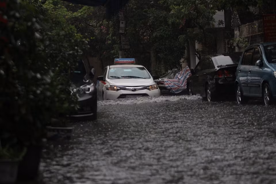 Trên phố Đặng Văn Ngữ, mực nước ngập có chỗ đến nửa bánh xe ô tô.