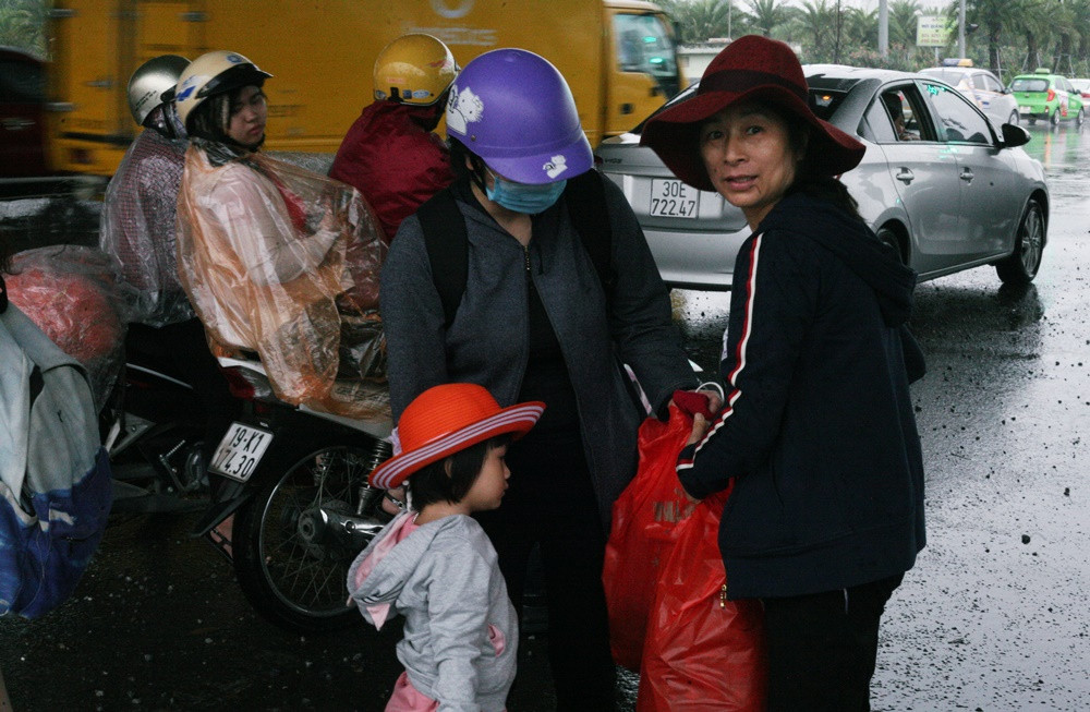 Nhiều gia đình đưa con em đi chơi dịp nghỉ lễ 30/4 nhưng gặp mưa lớn đành phải trú tạm dưới các gầm cầu vượt.