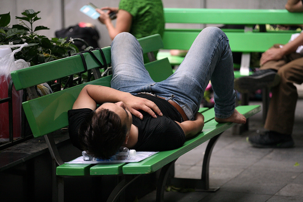 Tận dụng chai nước để làm gối nằm trên ghế ở vỉa hè bệnh viện Bạch Mai.