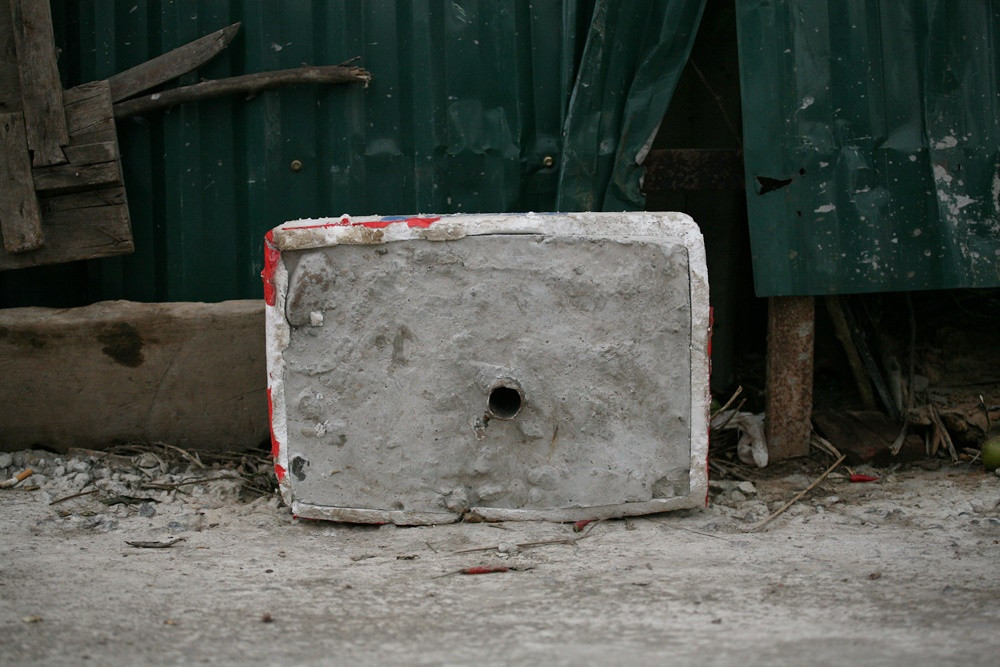 Trụ bê tông mà tiểu thương đúc để dựng ô che tại sạp hàng.