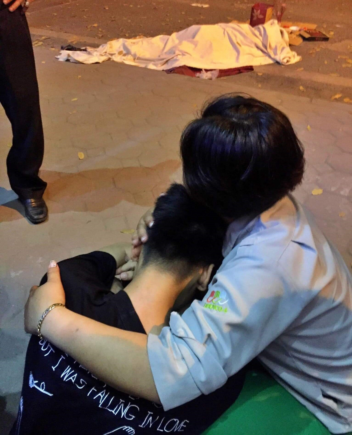 Đồng nghiệp nạn nhân an ủi cháu bé trong khi đợi cơ quan chức năng khám nghiệm hiện trường để bàn giao thi thể.