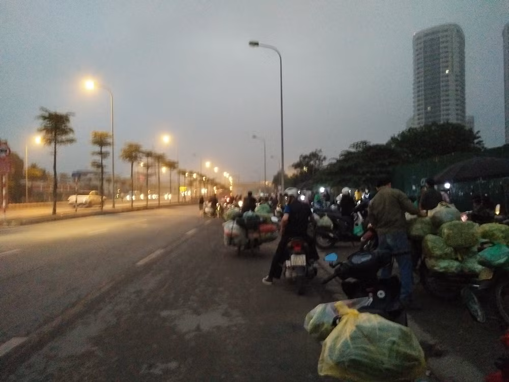 Những người buôn bán thường tụ tập đến chợ không phép trên phố Trần Quốc Vượng (phường Dịch Vọng Hậu, quận Cầu Giấy, TP Hà Nội) từ khoảng 2h đến 8h sáng mỗi ngày. Cách nút giao đường Phạm Hùng - Trần Quốc Vượng khoảng 10m bắt đầu xuất hiện cảnh tượng lấn chiếm lòng đường, vỉa hè để họp chợ.