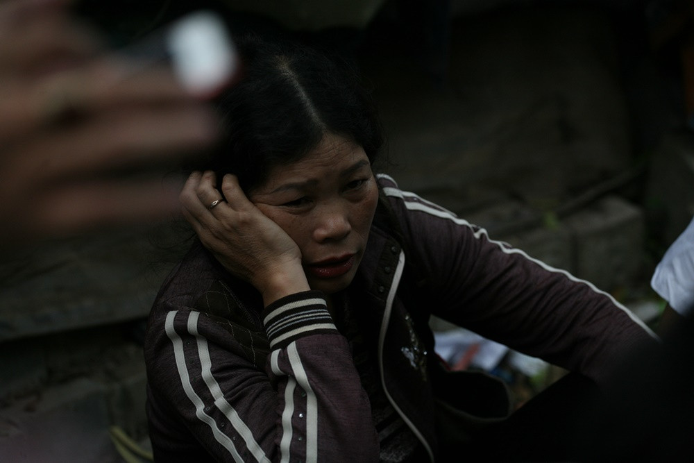 Bà Lê Thị Ná (Chương Mỹ, Hà Nội) đau buồn, ngồi phía ngoài hiện trường cho biết, gia đình có con và cháu đang bị mất tích.