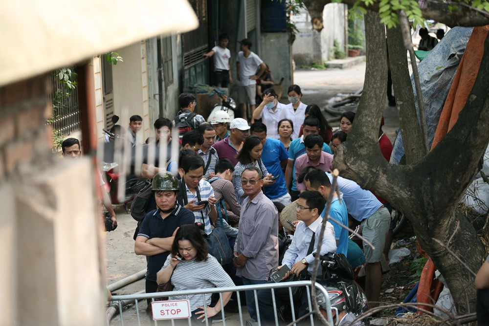 Thân nhân các nạn nhân đứng xa ở phía ngoài, cũng như các phóng viên phải tác nghiệp xa không được vào phía trong hiện trường.