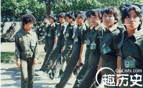 Các nữ quân nhân đang tập bước theo kiểu nhà binh nhưng vẫn ngậm một cái gì đó trong miệng. Điều này chưa rõ nhằm mục đích gì.