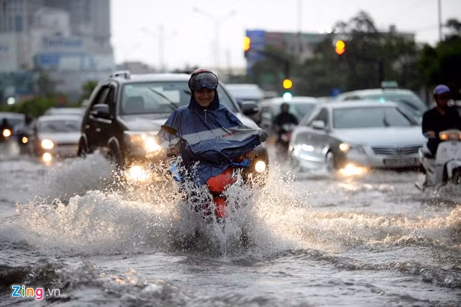 Xe máy chen chúc vào làn đường dành cho ôtô để tránh vùng nước ngập sâu.