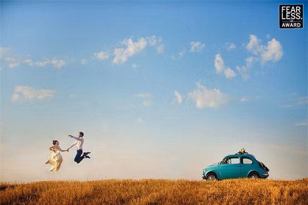 Bức ảnh cưới lãng mạn của đôi vợ chồng trẻ dưới bầu trời xanh trải nắng vàng. \