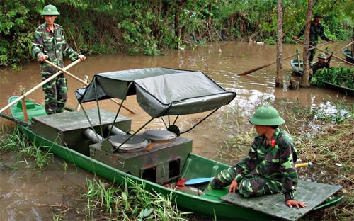 Chiến sĩ hậu cần sử dụng bếp Hoàng Cầm trên sông, phục vụ tốt bữa ăn cho bộ đội trong lúc hành quân, huấn luyện.
