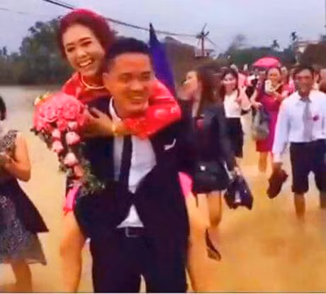 Trong số những hình ảnh bão số 10 được dân mạng chia sẻ, không ít người ấn tượng với đoạn clip chú rể cõng cô dâu về nhà ở Hải Phòng giữa ngày mưa bão. Đến đoạn đường ngập, chú rể đã cởi giày, cõng cô dâu trong tiếng reo hò của quan khách. Dù bất tiện, vất vả nhưng trên môi ai cũng nở nụ cười tươi vui.