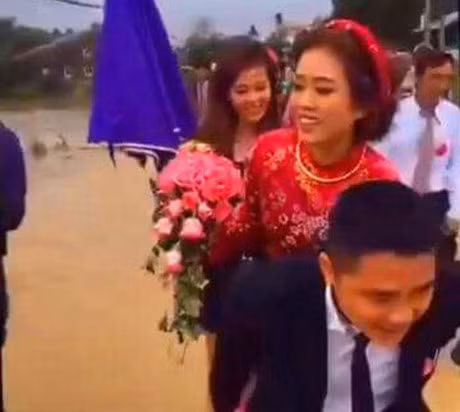 Ngập lụt, mưa xối xả không khiến ngày vui của cặp đôi trẻ tuổi bị ảnh hưởng.