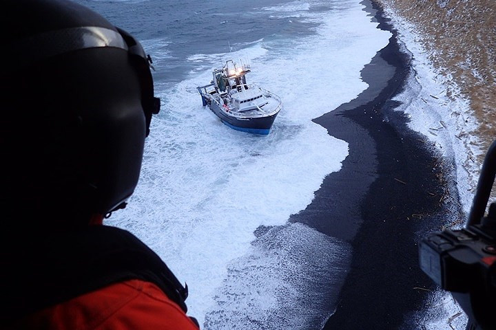 Trực thăng MH-60 Jayhawk thăm dò khu vực quanh tàu đánh cá này trước khi kéo nhấc 3 người ra khỏi đó.