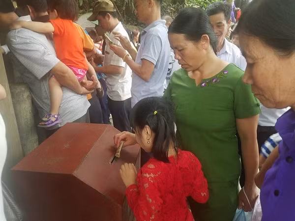 Bỏ tiền vào hòm công đức cạnh giếng cổ là hành động văn minh, lịch sự, tỏ lòng thành kính, cũng như làm tấm gương tốt cho con cháu. Ảnh Ngô Hùng