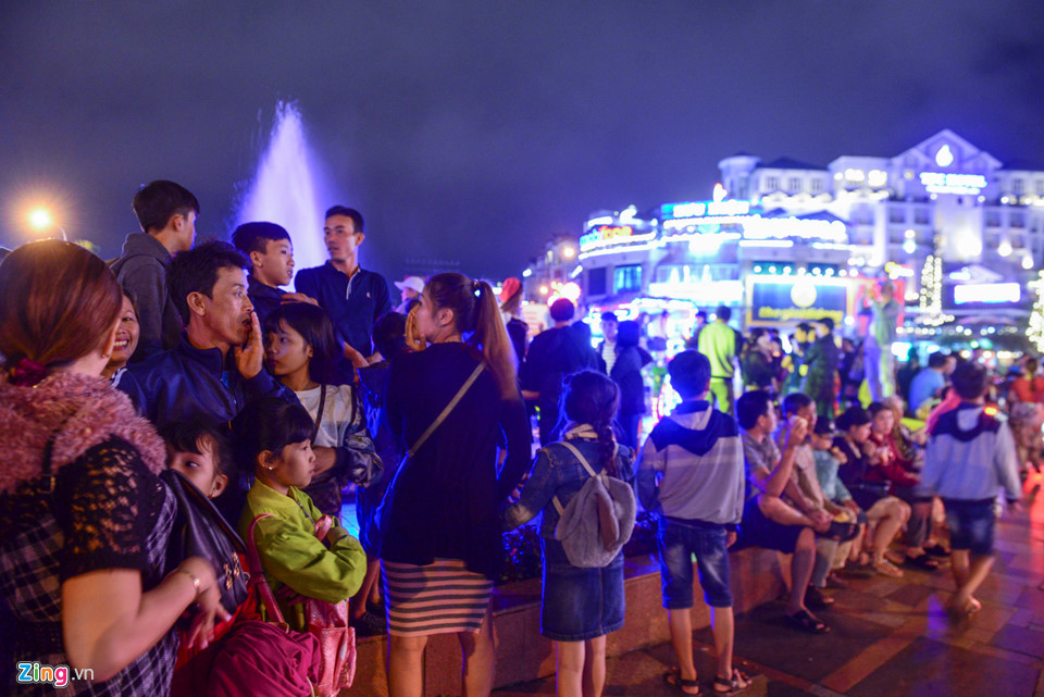 Quanh khu vực vòng xoay chợ đêm gần Hồ Xuân Hương, người dân tụ tập, ngồi nghỉ.