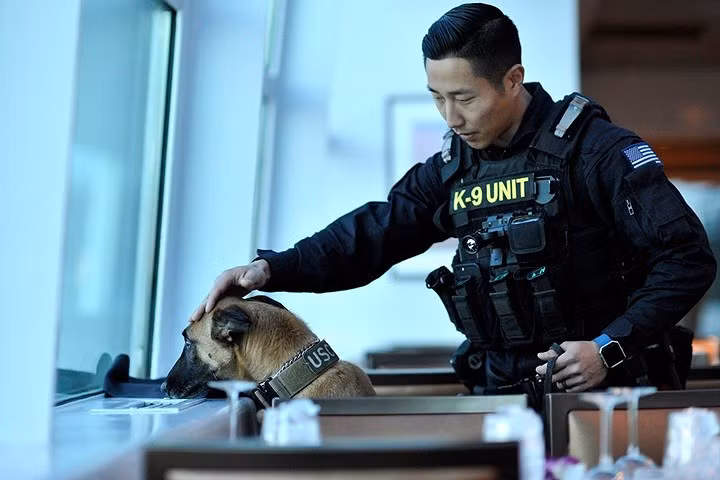 Một hạ sĩ quan tuần duyên thuộc đơn vị an ninh an toàn hàng hải New York và chú chó nghiệp vụ của mình.