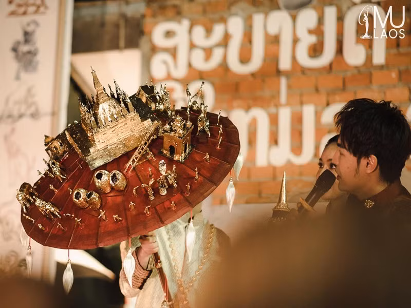 Quốc phục gồm một vị thần bốn đầu, trang phục lấy cảm hứng từ cố đô Luang Prabang, chiếc ô màu đỏ sẫm gắn hình ảnh thu nhỏ của các địa danh nổi tiếng và một chiếc khẩu trang. Ảnh: Hoa hậu Hoàn vũ Lào