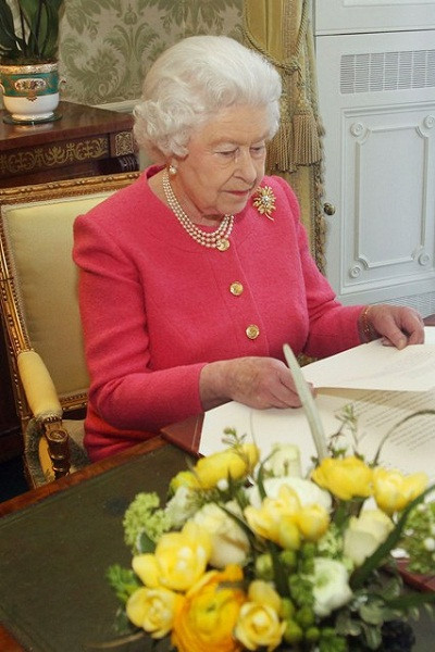Ngày 11/3/2013: Bức hình được chụp trong một ngày bình thường, Nữ hoàng làm việc trong văn phòng tại Lâu đài Buckingham. Bộ trang phục mang đậm phong cách riêng của bà với sắc màu tươi sáng và đồ nữ trang làm bằng ngọc trai.