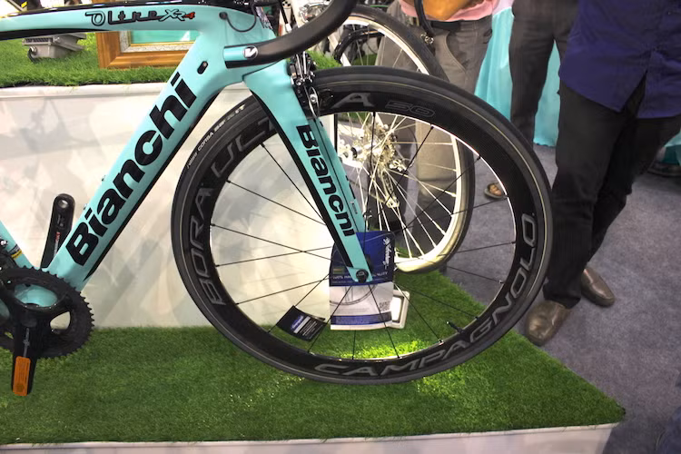 Ở phía trước, chiếc xe cũng có bộ càng full carbon. Vành của xe là loại Bora Ultra 50 do hãng Campagnolo và cũng có viền ngoài làm từ loại vật liệu đắt giá này. Đi kèm với vành là lốp vân dọc Vittoria Corsa với kích thước 700 x 25