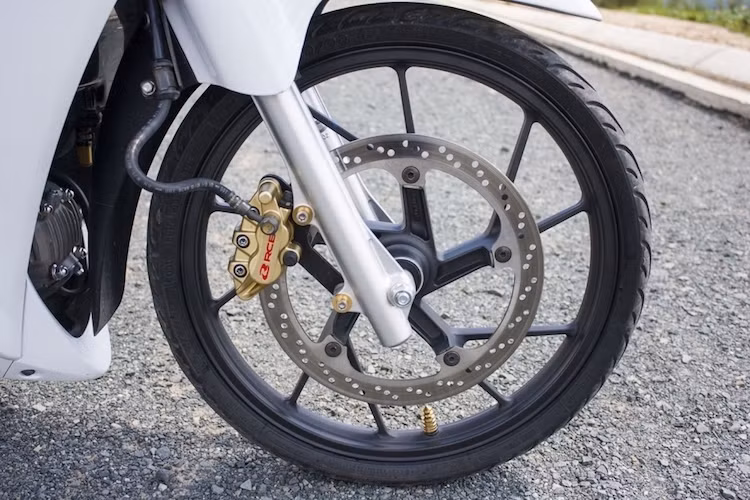 Trên chiếc xe này, "dàn chân" nguyên bản với niềng căm của Future Neo đã được thay bằng bộ vành 5 cây chữ Y kiểu "xương cá" của Suzuki Raider. Hệ thống phanh trước của xe cũng đã được nâng cấp bằng heo Racing Boy.