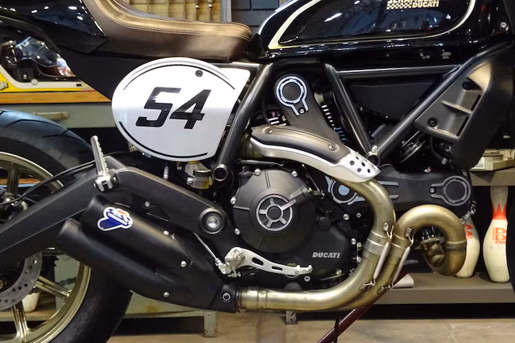 Nằm giữa bộ khung của Scrambler Cafe Racer vẫn là khối động cơ Desmodue 803 cc SOHC 2 van làm mát bằng không khí, có công suất tối đa 75 mã lực, mô-men xoắn cực đại 68,8 Nm như những phiên bản Scrambler khác. Tuy nhiên, điểm nhấn trên phiên bản này đó là nó được trang bị sẵn pô độ Termignoni 2 nòng.