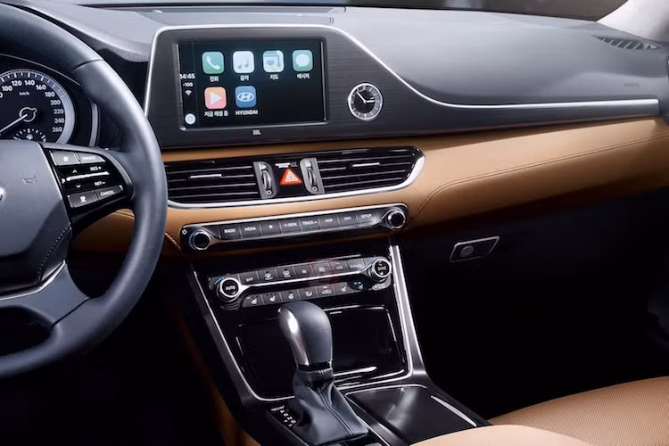 Nằm trên bảng táp-lô của xe, hệ thống thông tin giải trí của Azera được bao quanh bởi một khung kim loại chạy ngang táp-lô, bên cạnh là chiếc đồng hồ kim tạo cảm giác sang trọng. Hệ thống giải trí của xe cũng chắc chắn sẽ hỗ trợ đầy đủ các tính năng như GPS và kết nối smartphone qua Android Auto hay Apple Carplay.