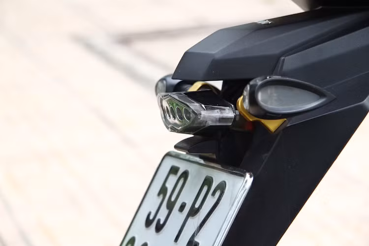 Trên pát biển số, cặp xi-nhan Rizoma Drop và đèn hậu Koso đã được gắn thêm cho chiếc xe, tăng độ an toàn khi đi trong đêm.