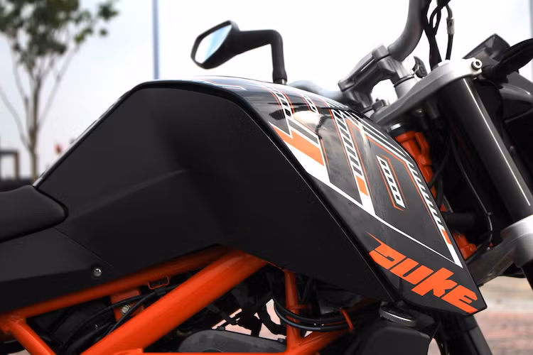 Vẻ đẹp của xe có được ở hai bên thân là nhờ vào phần vỏ ốp bình xăng được thiết kế sắc sảo, góc cạnh và khỏe khoắn hơn. Trên phiên bản "đời cuối" này, chiếc xe vẫn có tem số 390 với kích thước lớn được dán hai bên bình xăng. Bản thân bình xăng của xe có dung tích 11 lít - nằm ở mức trung bình so với các đối thủ khác.