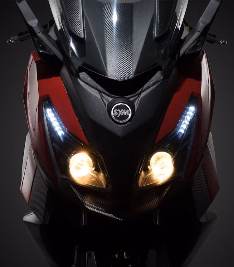 Ở phía trước, cũng giống như MAXSYM 500, CruiSYM 300i cũng sở hữu cặp đèn pha kép với 2 bóng pha dạng thấu kính projector và đèn chiếu sáng ban ngày LED. Tuy nhiên so với MAXSYM, cụm đèn pha của xe đã có thiết kế khá khác biệt với kích thước to hơn, nhưng ít sắc sảo hơn.