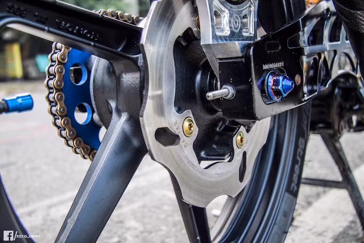 Bánh sau của xe cũng có mâm CBR150, đi kèm hệ thống phanh với pát nhôm CNC và heo Brembo 2 pis đối xứng. Thay vì càng và phuộc nguyên bản, chiếc Exciter 135 này đã được thay bộ phuộc monoshock và gắp sau bằng nhôm của hãng Racing Boy. Với cặp lốp Michelin Pilot Street, chiếc xe cũng có độ bám đường cao hơn.