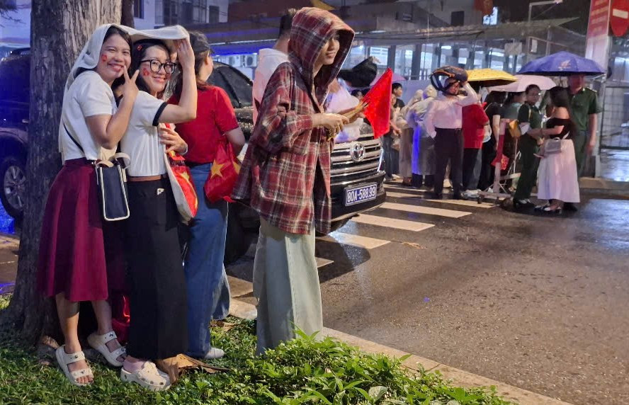 Cơn mưa bất chợt cũng không làm giảm đi sự nhiệt tình của người dân