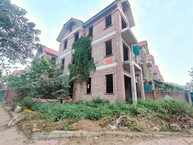 Những ngôi biệt thự đang được xây dựng dở dang giờ đây nằm “đắp chiếu” trong cỏ cây, rêu phong phủ kín. 