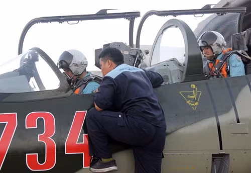 Nhân viên kỹ thuật hỗ trợ phi công mở máy huấn luyện.