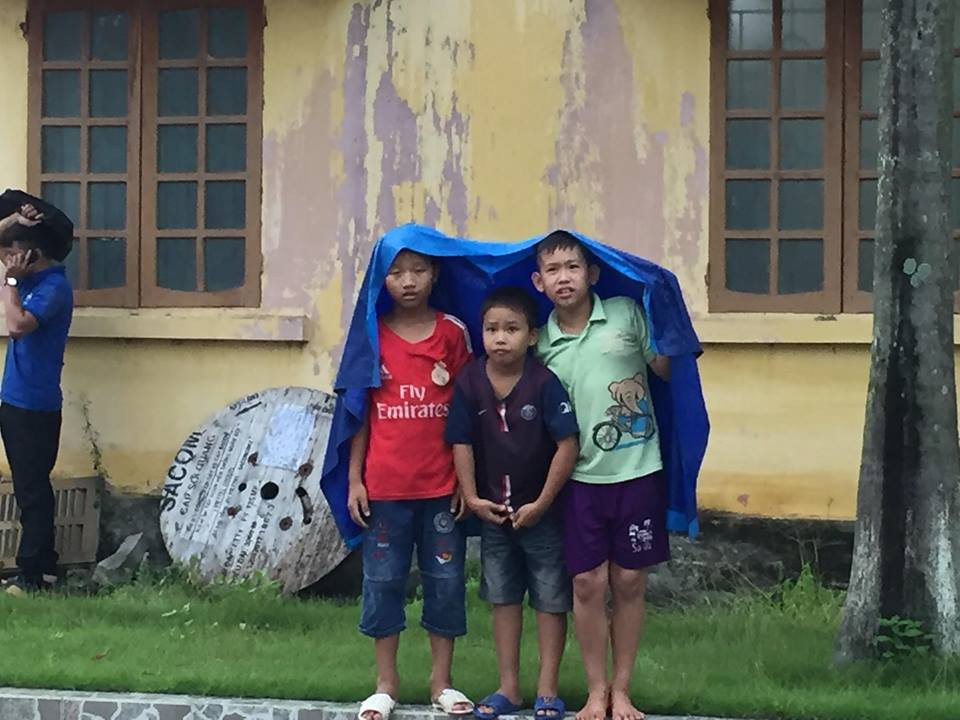 Trời mỗi lúc càng mưa nặng hạt, nhưng các em nhỏ vẫn đội mưa để cổ vũ.