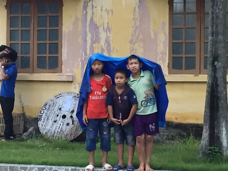 Trời mỗi lúc càng mưa nặng hạt, nhưng các em nhỏ vẫn đội mưa để cổ vũ.