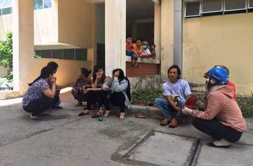 Thân nhân các nạn nhân đang ngồi trước nhà đại thể để nhận dạng người thân của mình.