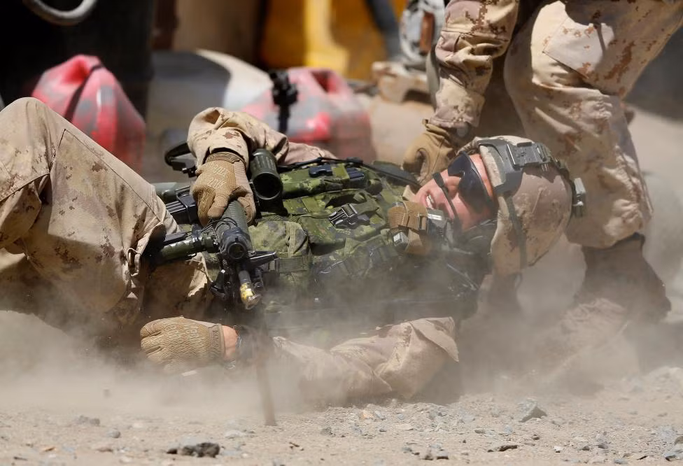 Lính Canada ngã sõng soài xuống đất trong lúc tập.