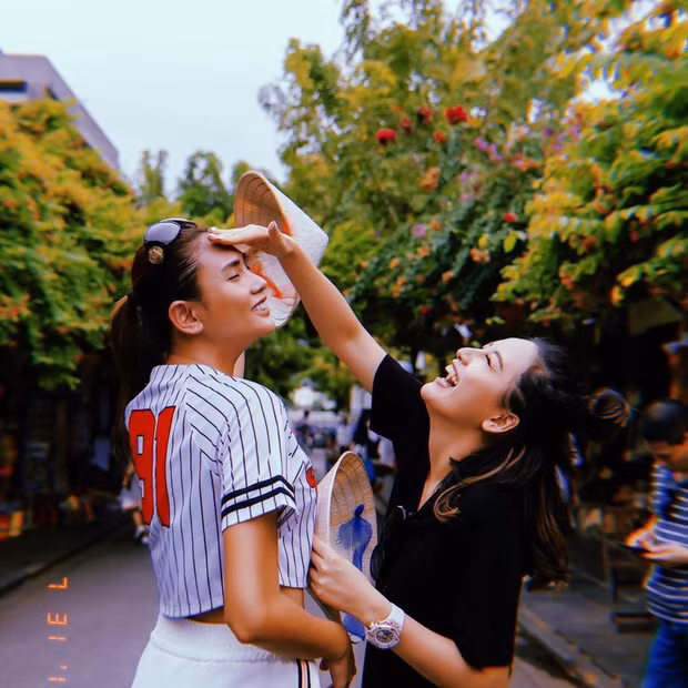 Hoa hậu Mai Phương Thúy và siêu mẫu Võ Hoàng Yến tạo dáng tinh nghịch giữa con đường phố cổ tràn ngập hoa. Ảnh: FBNV.