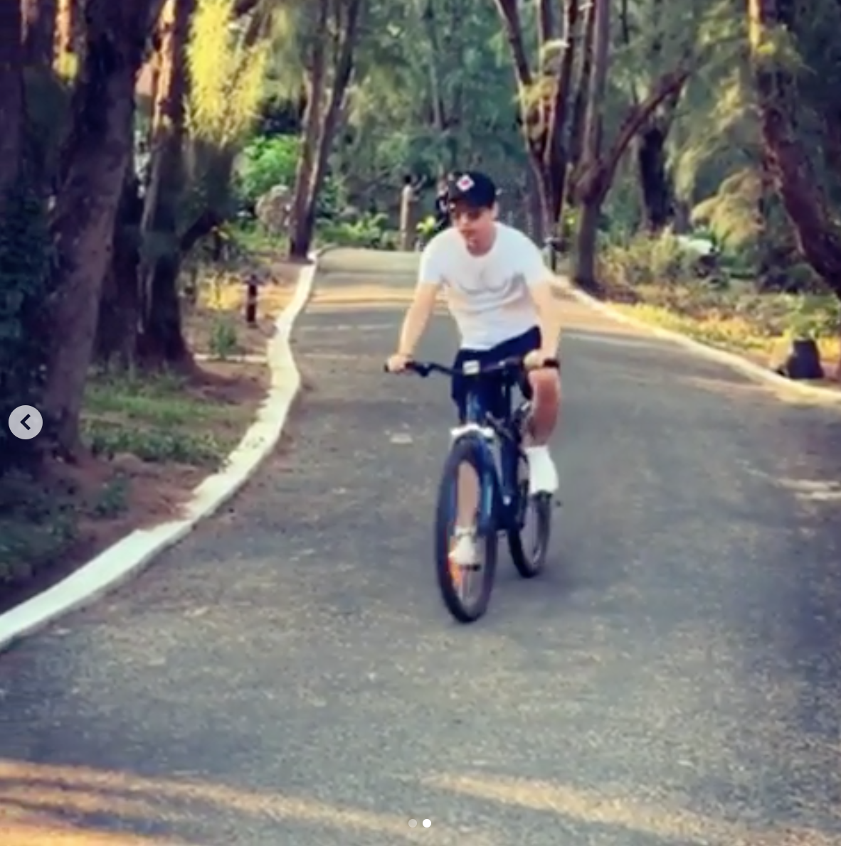 Hồ Quang Hiếu đăng clip đạp xe trên một con đường rợp bóng cây.