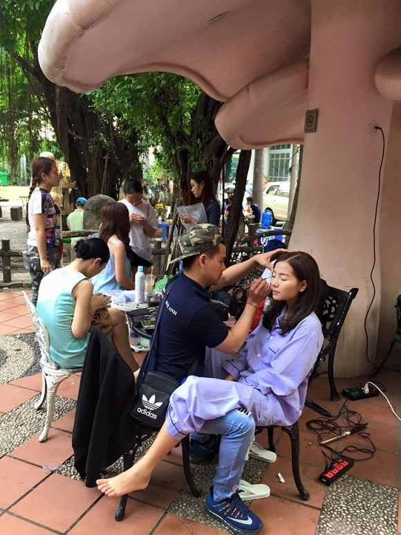 Diễn viên Khánh Hiền vừa trang điểm vừa vô tư gác chân lên đùi của chuyên gia make-up nam.