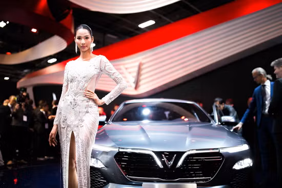 Á hậu Hoàng Thùy nổi bật khi làm người mẫu quảng cáo xe tại Paris Motor Show 2018 trong bộ đầm dạ hội thướt tha xẻ tà của nhà thiết kế Linh San.