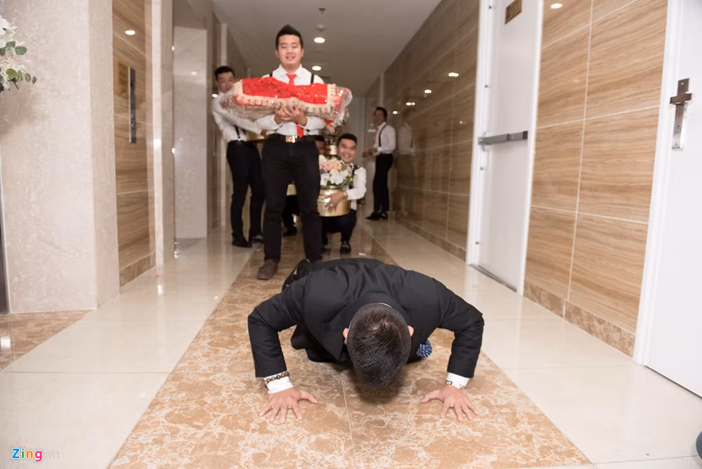 Trước khi vào nhà gái, chú rể phải vượt qua thử thách của đội phù rể. Theo đó, bạn bè yêu cầu ông xã Giang Hồng Ngọc hít đất nhiều lần mới được vào đón dâu. Chú rể chứng tỏ sức bền bỉ khi hít đất liên tục 50 lần.
