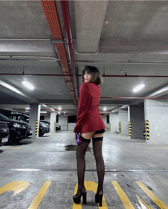 Áo blazer đỏ kết hợp với tất lưới và giày cao gót màu đen "tông xuyệt tông", tình cũ Hạ Vi táo bạo khoe vòng 3 lấp ló ở hầm để xe.