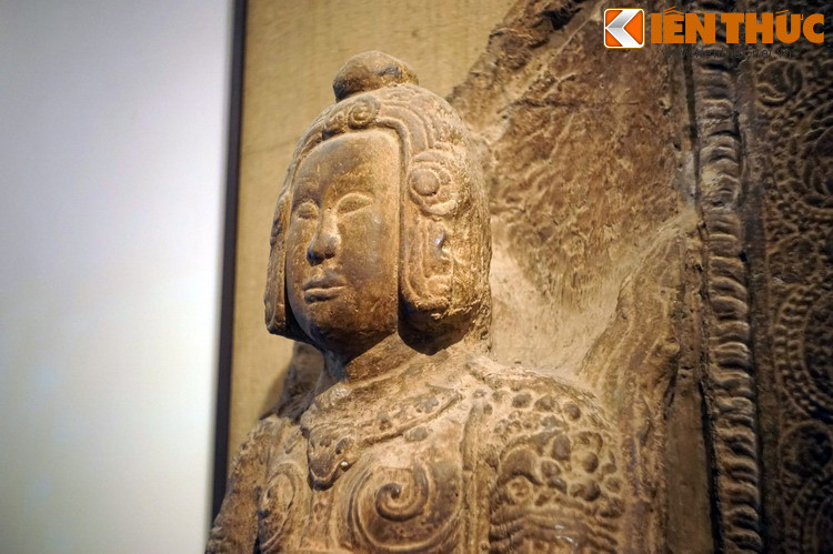 Giữa trán và chóp mũ nổi lên những đường gờ tạo thành hình vòng nối xuống những bông hoa cúc cách điệu hai bên mang tai.