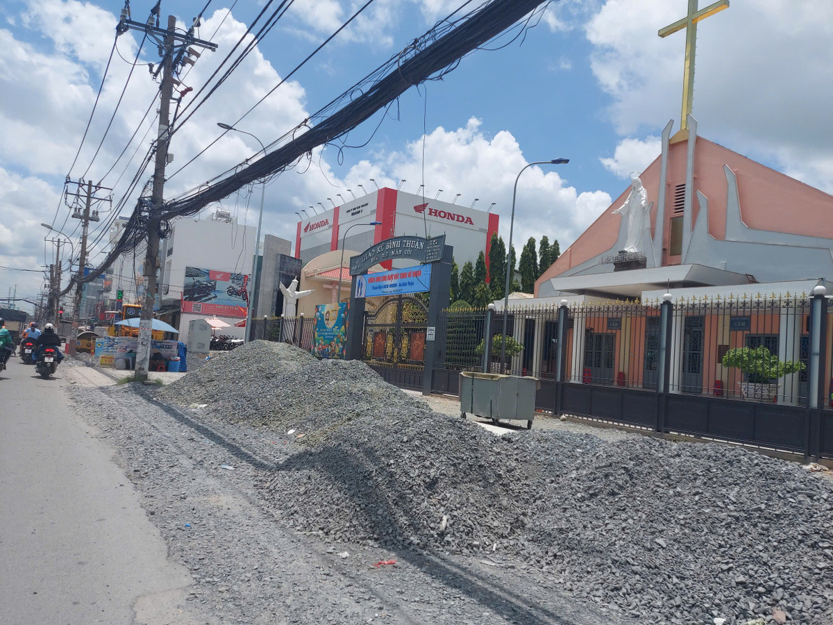 Vật tư và phương tiện thi công được nhà thầu tập kết quanh khu vực giáo xứ Bình Thuận nhưng thiếu biển cảnh báo an toàn cho người đi đường.