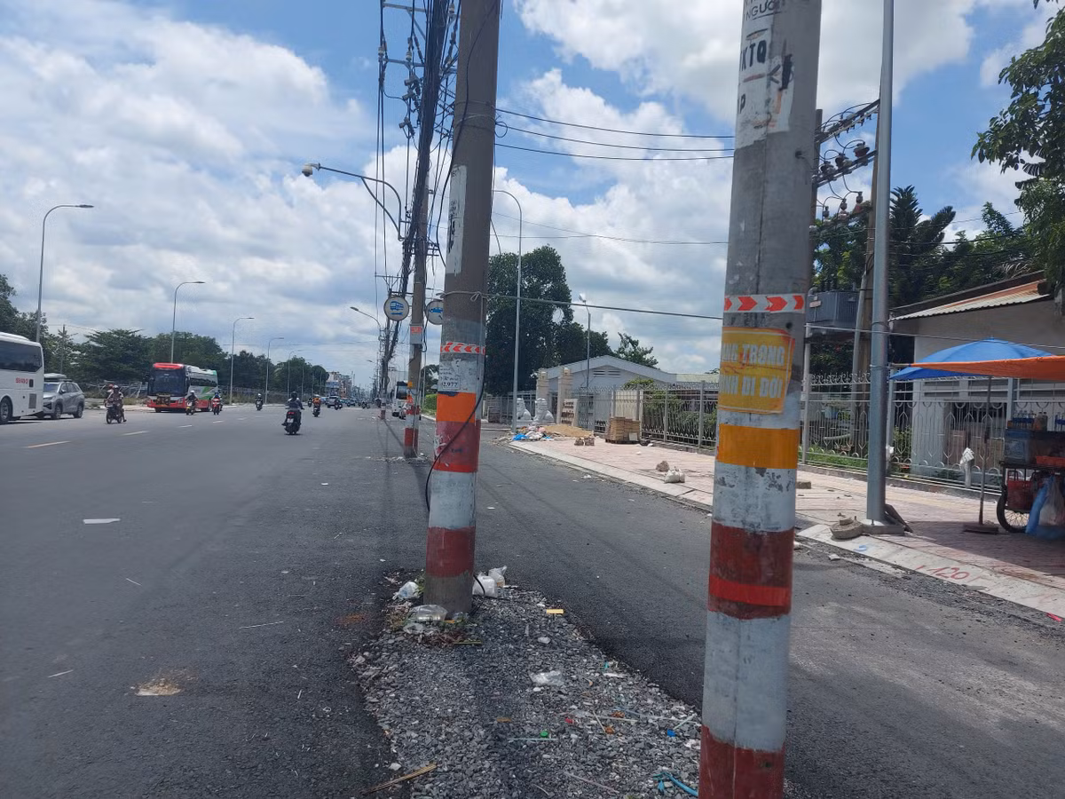 Tuy nhiên, ở bên lề phải, các cột điện kèm dây chằng chịt vẫn chình ình cả đoạn dài. Việc này không chỉ ảnh hưởng đến tiến độ toàn dự án mà còn gây nguy hiểm đến người đi đường, mất mỹ quan đô thị.