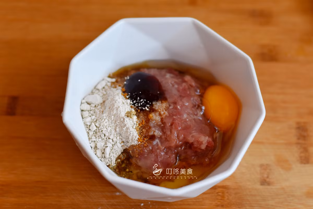 Bước 1: Băm nhỏ thịt heo, cho lượng muối thích hợp, bột bắp, xì dầu nhạt, dầu hào, dầu ăn, trứng gà vào, đảo đều tay theo một chiều cho đến khi săn lại.