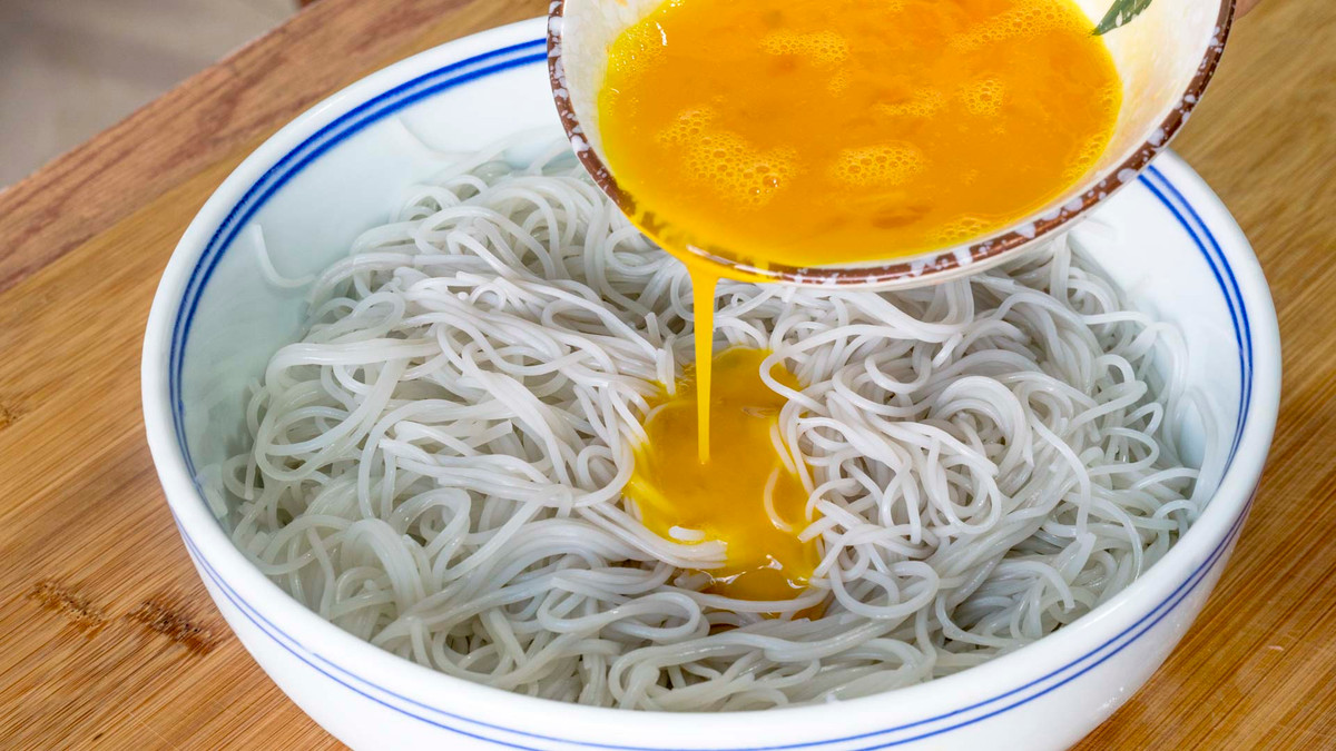 Đổ trứng lên miến, chú ý cho vào bát to để lúc sau còn trộn các loại củ.