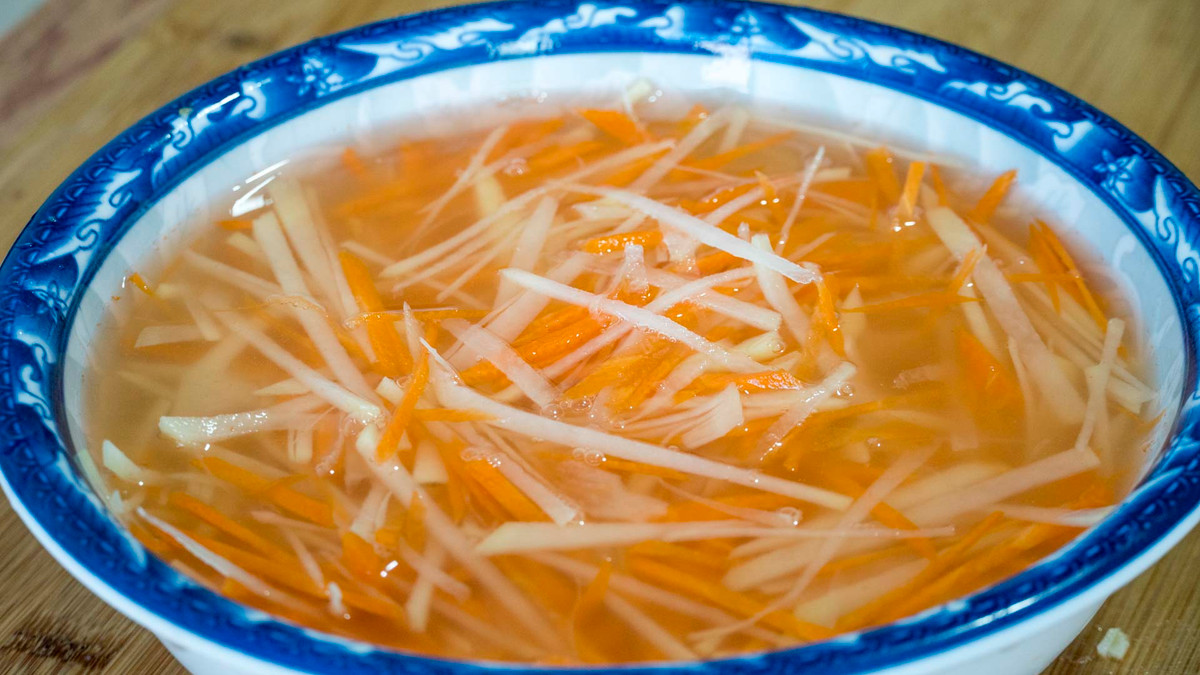 Trong lúc chờ đợi, ta gọt vỏ, thái sợi khoai tây và cà rốt, ngâm trong nước. Ớt xanh cũng bỏ hạt thái sợi.